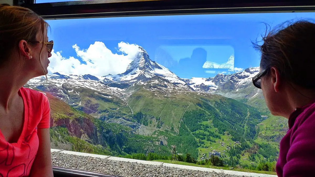 A Gornergrat Bahn cogwheel train climbing above Zermatt with the Matterhorn behind