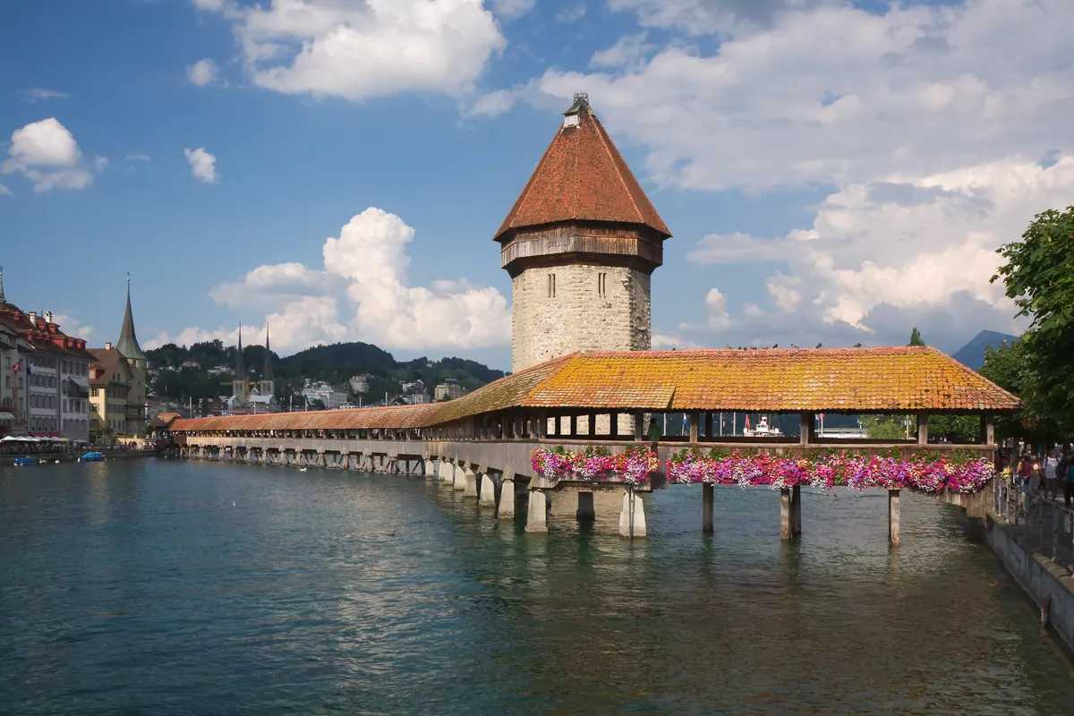 The covered wooden Chapel Bridge and its stone Water Tower crossing the Reuss River in Lucerne