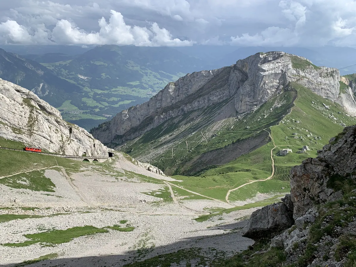 A Pilatus cogwheel railway train climbing below the rocky Matthorn on Mount Pilatus