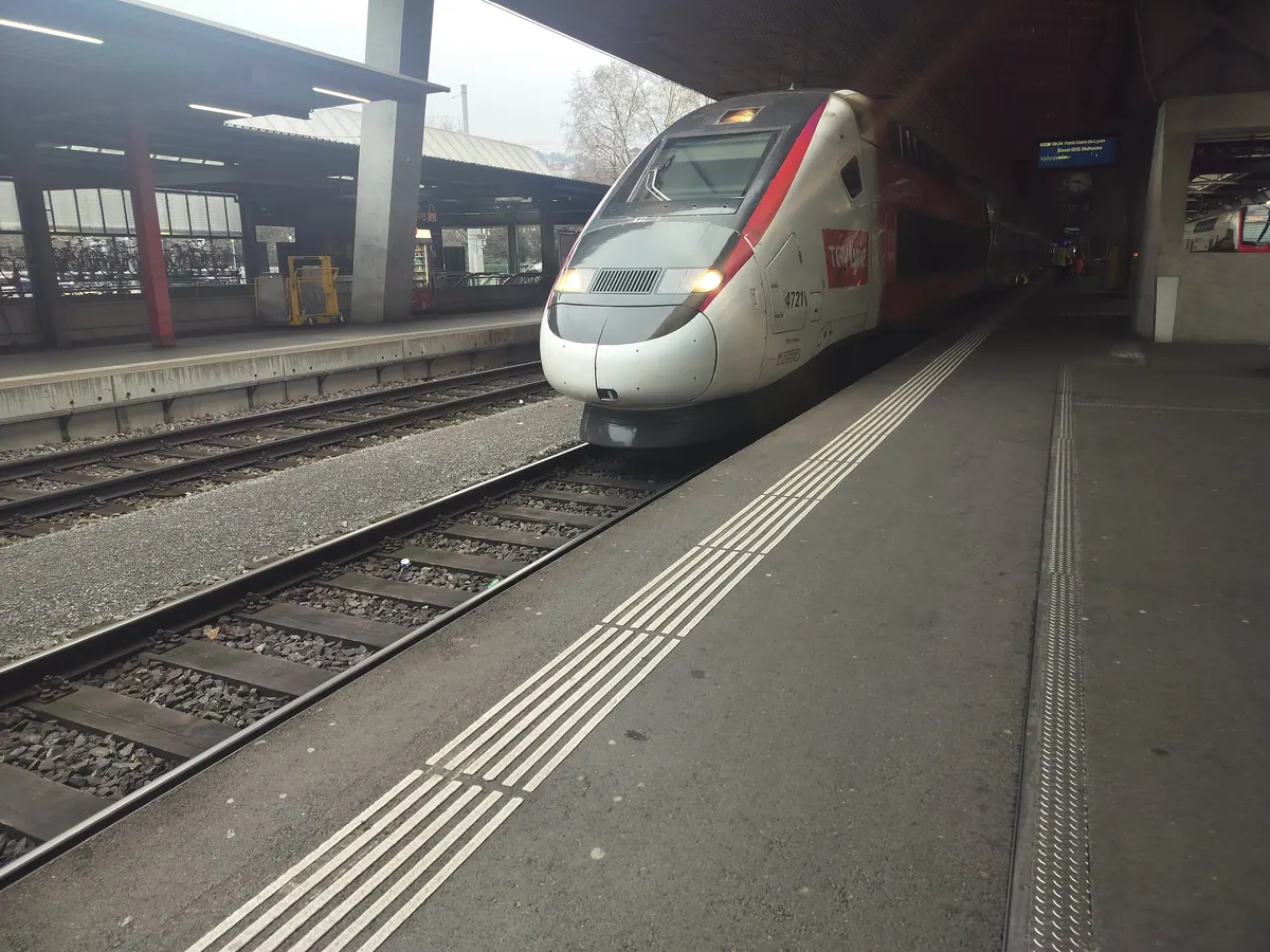 A red and white TGV Lyria high-speed train at the platform in Zurich HB